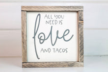 Load image into Gallery viewer, Wood framed sign featuring the saying, &quot;All you need is love and tacos.&quot; Frame is stained in Classic Gray finish. Sign is cream with gray vinyl lettering